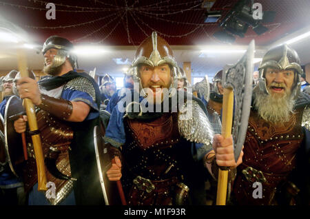 Les membres de l'équipe de Jarl vêtus de costumes Viking chanter dans la Royal British Legion club avant marche dans les rues de Lerwick sur les îles Shetland pendant le Festival Up Helly Aa Viking. Banque D'Images