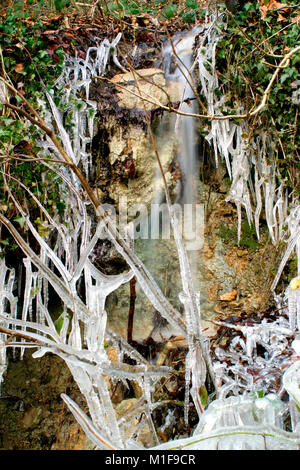 Les glaçons autour d'une petite roche stream par temps froid Banque D'Images