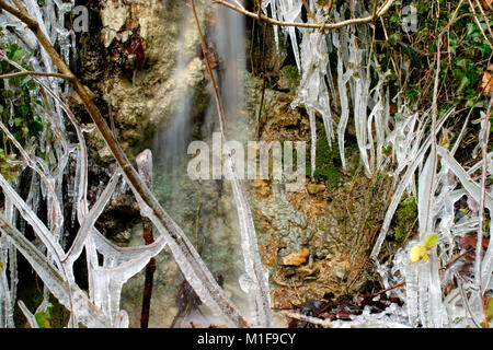Les glaçons autour d'une petite roche stream par temps froid Banque D'Images