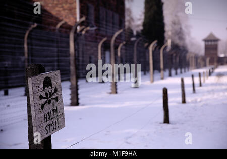 Signe de tête de mort "Halt" près de clôtures électriques et de barbelés entourant Auschwitz I et Musée commémoratif de l'Holocauste - Pologne Banque D'Images