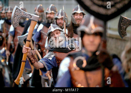 Les membres de l'équipe de Jarl vêtus de costumes Viking marche dans les rues de Lerwick sur les îles Shetland pendant le Festival Up Helly Aa Viking. Banque D'Images