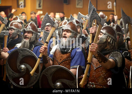 Les membres de l'équipe de Jarl vêtus de costumes Viking le chant dans la Royal British Legion club avant marche dans les rues de Lerwick sur les îles Shetland pendant le Festival Up Helly Aa Viking. Banque D'Images