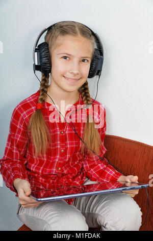Jolies filles listening music on tablet PC Banque D'Images
