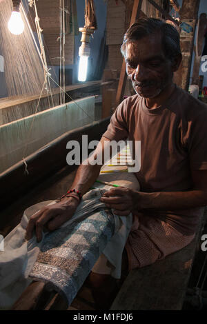 La broderie de soie traditionnelle avec l'homme de l'usine de tissage sur le métier à tisser, à Varanasi, Uttah Pradesh, Inde Banque D'Images