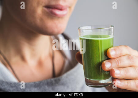 Woman holding shot de jus de wheatgrass Banque D'Images