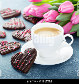 Coeurs de chocolat cookies avec nutrifer pour la Saint-Valentin avec une tasse de café et de fleurs pour le petit déjeuner Banque D'Images