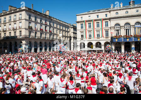 Foule de gens habillés en blanc et rouge à la fête d'été des fêtes de Bayonne (Bayonne), France Banque D'Images