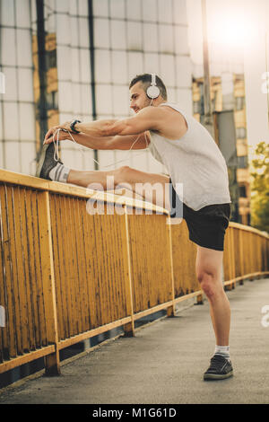 Jeune athlète faisant l'exercice d'étirement, la préparation à l'entraînement du matin. Fitness, sport, style de concept Banque D'Images