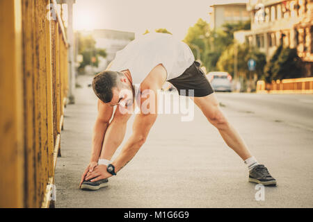 Jeune athlète faisant l'exercice d'étirement, la préparation à l'entraînement du matin. Fitness, sport, style de concept Banque D'Images