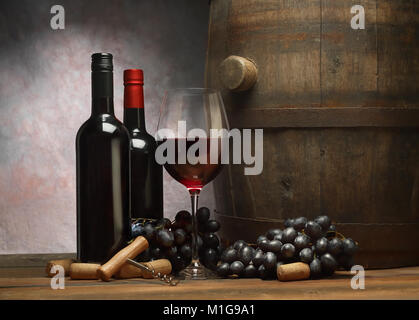 Nature morte avec un vieux baril, bouteilles de vin, verre de vin rouge et de raisin noir Banque D'Images