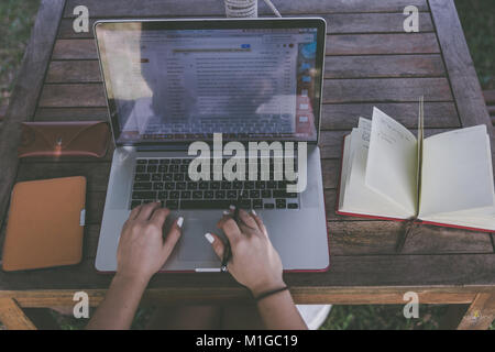 Hipster élégant de l'analyse financière, économiste de l'homme incombait à plat avec un ordinateur portable et des papiers, café et téléphone. freelancer concept. Offres d'une des données Banque D'Images