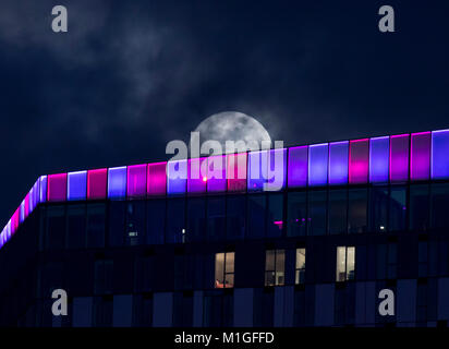 La lune s'élève derrière le bâtiment de la place Saffron à Croydon, devant un événement céleste « inhabituel », mercredi soir, lorsqu'une lune bleue se lève dans le ciel pour la première fois depuis juillet 2015. Banque D'Images