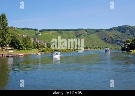 Bateaux à moteur croisière sur la rivière Moselle, derrière l'église Saint Maternus de vin village Uerzig, Moselle, Rhénanie-Palatinat, Allemagne, Europe Banque D'Images