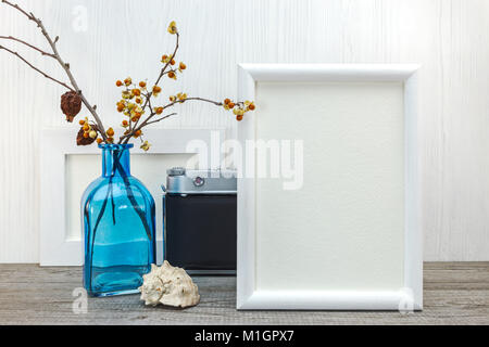Cadres photo vide, vase en verre bleu avec des fleurs séchées, seashell on white background Banque D'Images