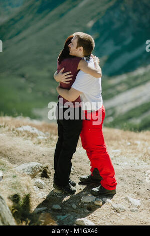 Portrait of a young couple embracing in nature au sommet des montagnes. Banque D'Images