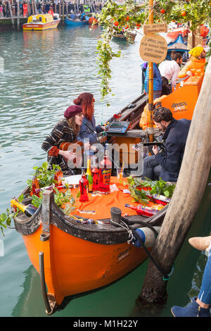 Les Vénitiens carnaval fête sur un bateau la promotion d'Aperol Spritz, Cannaregio, Venise, Italie avec des musiciens après la Festa sull'Acqua pre- Banque D'Images