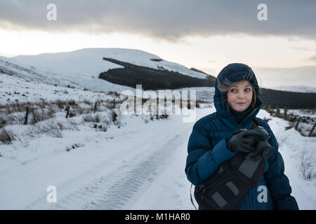 Femme photographe dans un manteau bleu paysages photos dans la neige en hiver Banque D'Images