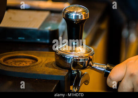 Barista est maintenant le portafilter et autosurveillance tout en se préparant pour l'espresso dans un café-restaurant moderne Banque D'Images