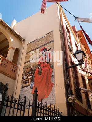 Illustrations sur un mur à Begur, Espagne, représentant une femme avec un cigare cubain au cours de la Fira d'Indians célébrations Banque D'Images