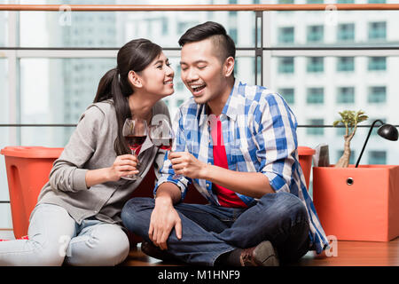 Les jeunes amoureux après le déplacement d'avoir un verre de vin après le travail Banque D'Images