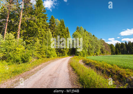 Le tournant de la route en milieu rural vide va près de green field under blue sky en plein jour d'été. Contexte photo paysage vide, Finlande Banque D'Images