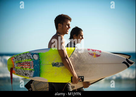 RIO DE JANEIRO - 6 février 2017 : les jeunes surfeurs brésilien à pied avec leurs planches de surf le long de la côte à l'Arpoador beach, spot de surf populaire. Banque D'Images