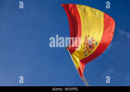 Photo de la levée du drapeau espagnol dans l'air par un après-midi ensoleillé avec un fond de ciel bleu. Ce drapeau est le symbole officiel du Royaume de Spa Banque D'Images