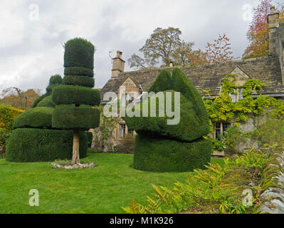 Topiaire assorties, y compris une tête de sanglier, en face d'une ancienne maison rurale dans le parc de Haddon Hall, Derbyshire, Royaume-Uni Banque D'Images