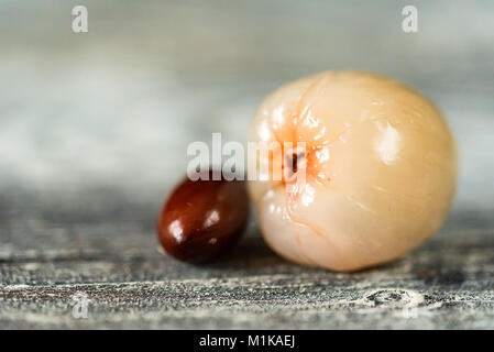 Litchi et de graines décortiquées sur fond de bois fermer Banque D'Images