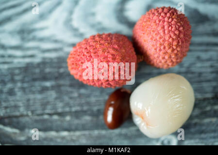 Trois fruits litchi et de semences sur fond de bois Banque D'Images