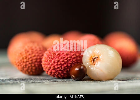 Semences et fruits litchi sur fond de bois Banque D'Images