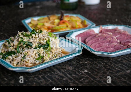 Accueil plats plats chinois dans la région rurale de Xi'an, province du Shaanxi, en Chine. Un plat de fèves germées, un plat de tranches de boeuf bouilli et derrière un plat o Banque D'Images