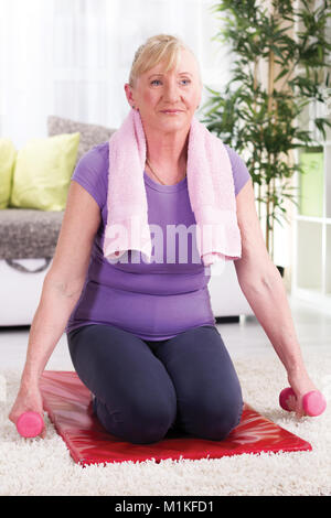 Senior woman exercice avec haltères à la maison Banque D'Images