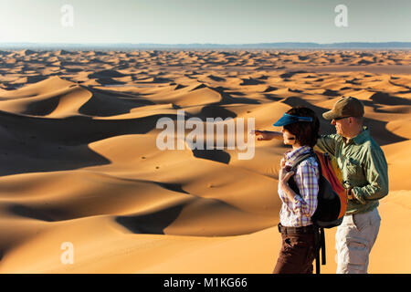 Le Maroc, Mhamid, Erg Chigaga dunes de sable. Désert du Sahara. Couple de touristes sur la dune de sable. Banque D'Images