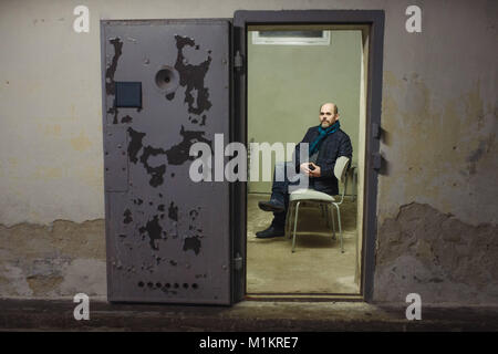 Le témoin contemporain et ancien prisonnier de la RDA, Hans-Joachim Lietsche, est assis à l'intérieur d'une cellule de l'ancienne prison et l'actuel site du mémorial de Hohenschönhausen à Berlin, Allemagne, 25 janvier 2018. Le mur de Berlin s'élevait à 28 ans, 2 mois et 26 jours. Le 5 février, le mur sera fait tant qu'elle durait. Photo : Gregor Fischer/dpa Banque D'Images