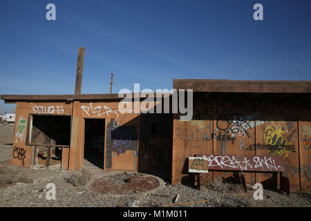 Bombay Beach, Californie, USA. 11Th Feb 2016. Couverts de graffitis bâtiments vides au bord de l'eau avant de Bombay Beach. Bombay Beach est une ville située dans la région de Imperial County, Californie du Sud. Il est situé sur le lac Salton et communautaire est le plus bas en Amérique, situé à 223 pieds (68 m) au-dessous du niveau de la mer. La population était de 295 au recensement de 2010. La Salton Sea est une solution saline, peu profond, le lac du rift endoréique situé directement sur la faille de San Andreas, principalement dans le sud de la Californie et de l'empire des vallées Coachella. Le point le plus profond de la mer est de 5 pi (1,5 m) plus élevé que la plus faible po Banque D'Images