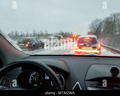 Tempête, pauvre voiture conduite sur routes glissantes et beaucoup de trafic, chasse-neige faisant l'enlèvement de la neige au cours de blizzard Banque D'Images