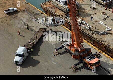 Les membres de l'Ouragan Maria FSE-10 transition vaisseaux touchés de l'équipe d'intervention d'une barge pour être transportés à des fins d'élimination dans le port de Ponce, Puerto Rico, le 26 janvier 2018. L'équipe était composée de membres de la Garde côtière et les équipes de sauvetage locales, travaillant dans le FSE-10 suppriment les bateaux qui étaient coincés dans l'ouragan. Le FSE-10 offre pas de frais, options pour enlever ces navires ; les propriétaires de bateaux concernés sont priés d'appeler la hotline de sensibilisation des propriétaires de navire au (786) 521-3900. (U.S. Photo de la Garde côtière du Maître de 2e classe Lara Davis) Banque D'Images