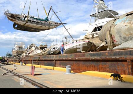 Les membres de l'Ouragan Maria FSE-10 transition vaisseaux touchés de l'équipe d'intervention d'une barge pour être transportés à des fins d'élimination dans le port de Ponce, Puerto Rico, le 26 janvier 2018. L'équipe était composée de membres de la Garde côtière et les équipes de sauvetage locales, travaillant dans le FSE-10 suppriment les bateaux qui étaient coincés dans l'ouragan. Le FSE-10 offre pas de frais, options pour enlever ces navires ; les propriétaires de bateaux concernés sont priés d'appeler la hotline de sensibilisation des propriétaires de navire au (786) 521-3900. (U.S. Photo de la Garde côtière du Maître de 2e classe Lara Davis) Banque D'Images