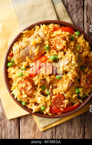 Arroz Valenciana avec lapin, chorizo, légumes et épices dans un bol sur la table. vertical haut Vue de dessus Banque D'Images