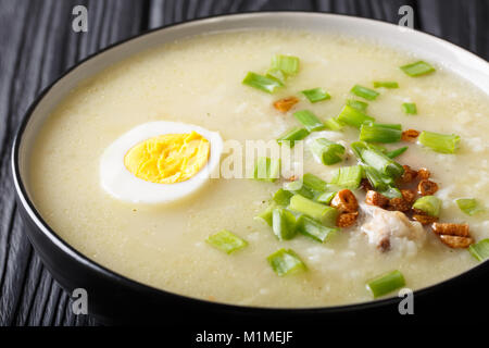 Arroz Caldo soupe de riz au poulet, l'ail, l'oignon et l'oeuf dans un bol, close-up horizontale. Banque D'Images