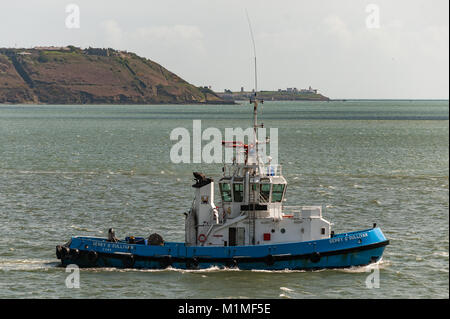 Port de Cork tugboat 'Gerry O'Sullivan' fait son chemin passé Cobh, dans le comté de Cork, Irlande avec Roches Point Lighthouse dans l'arrière-plan. Banque D'Images