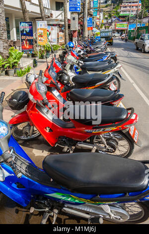 Une scène typique en Asie du sud-est. Beaucoup de motos parking très près les uns des autres dans une rangée au bord de la route du Soi, Pakbang à côté de la plage de Kata. Banque D'Images