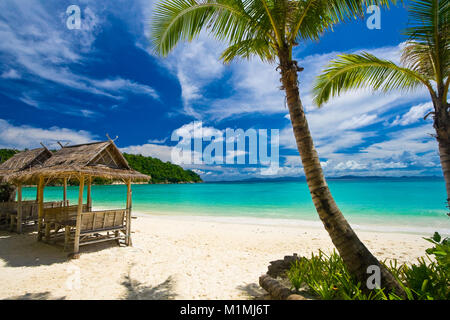 Paysages paradisiaques sur la magnifique plage de Siam Bay avec des palmiers sur le droit et les structures de chaume sur la gauche. Siam Bay est sur l'île de Racha Banque D'Images