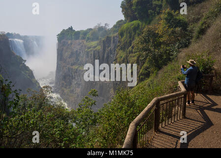 Homme photographiant les chutes Victoria , Zimbabwe Banque D'Images