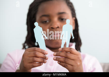 Close-up of Sad Girl Holding mère divorcée du père et les chiffres en mains papier Banque D'Images