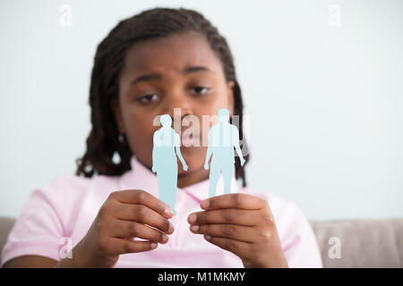 Close-up of Sad Girl Holding mère divorcée du père et les chiffres en mains papier Banque D'Images