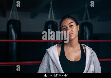 Close up of a female boxer debout à l'intérieur d'un ring de boxe. La formation à un Boxer boxing studio. Banque D'Images