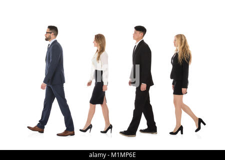 Société multiraciale Businesspeople Walking in Row Against White Background Banque D'Images