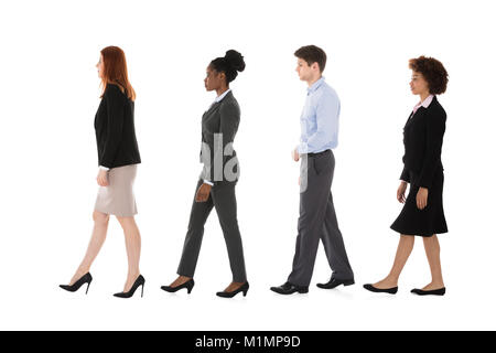 Société multiraciale Businesspeople Walking in Row Against White Background Banque D'Images